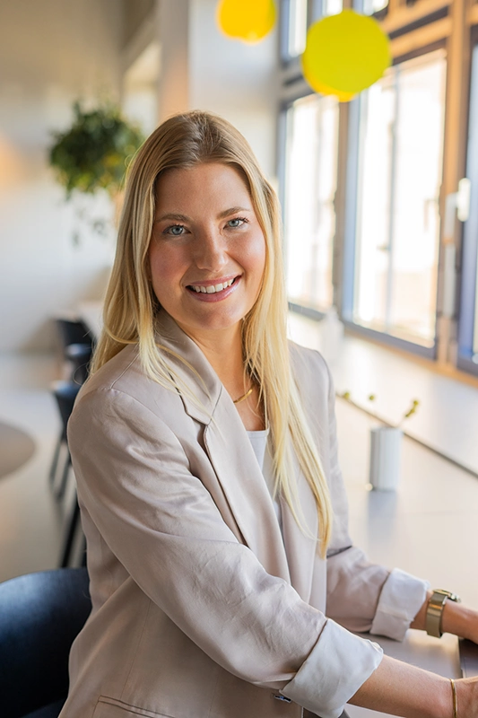 Businessfrau in casual Business-Kleidung sitzt an Theke und lächelt nach vorne - Personal Branding Fotograf Stuttgart