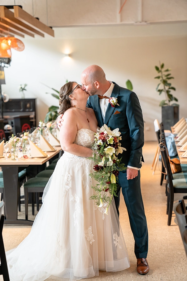 Hochzeit Schmellbachtal - Brautpaar küsst sich im Festsaal Waldblick