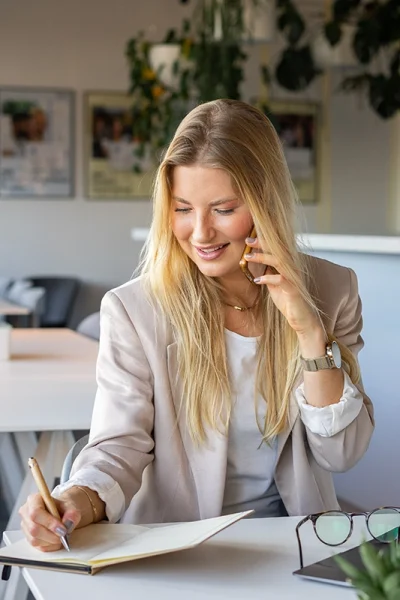 Businessfrau in hellem Blazer gekleidet telefoniert und schreibt - Personal Branding Fotograf Stuttgart