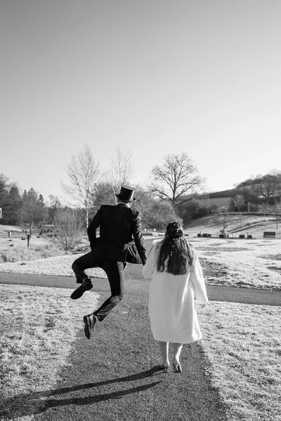 Brautpaar läuft weg, Bräutigam hüpft hoch