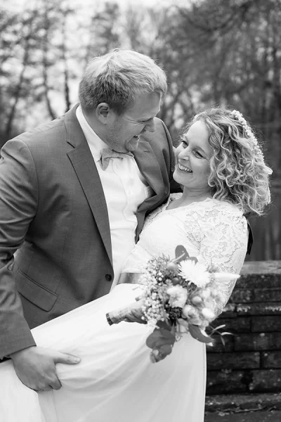 Fröhliches Hochzeitspaar in schwarzweiß