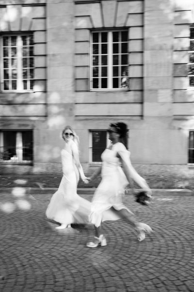 Zwei Bräute mit Sonnenbrillen laufen schnell in der Stadt, city vibes Hochzeit